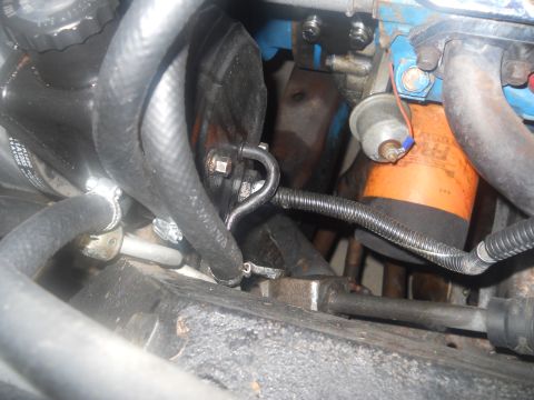 1976 Ford Bronco - Close-up view of engine components, including hoses and an oil filter.