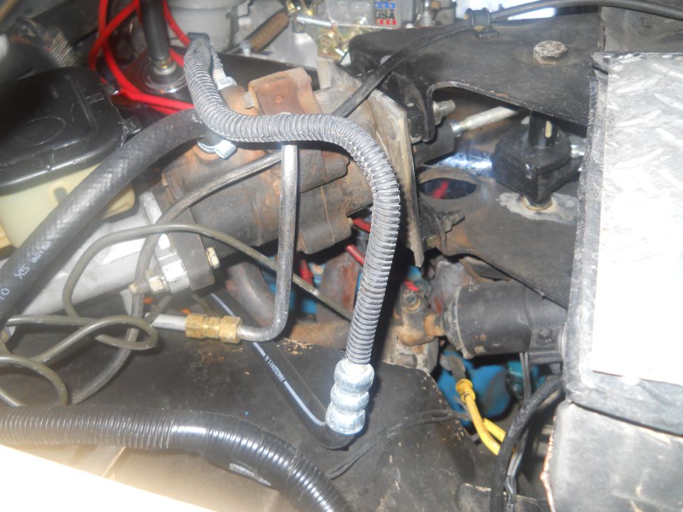 Engine bay with brake lines, hoses, and electrical wiring visible
