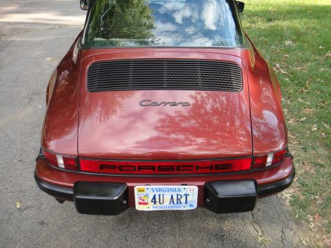 1986 Porsche 911 - Rear view of a 1986 Porsche 911 Carrera, showing the 'Carrera' script and 'PORSCHE' lettering.