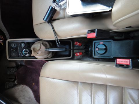 1986 Porsche 911 - The interior of this 1986 Porsche 911 shows the center console with its manual transmission shifter and seatbelt mechanisms.
