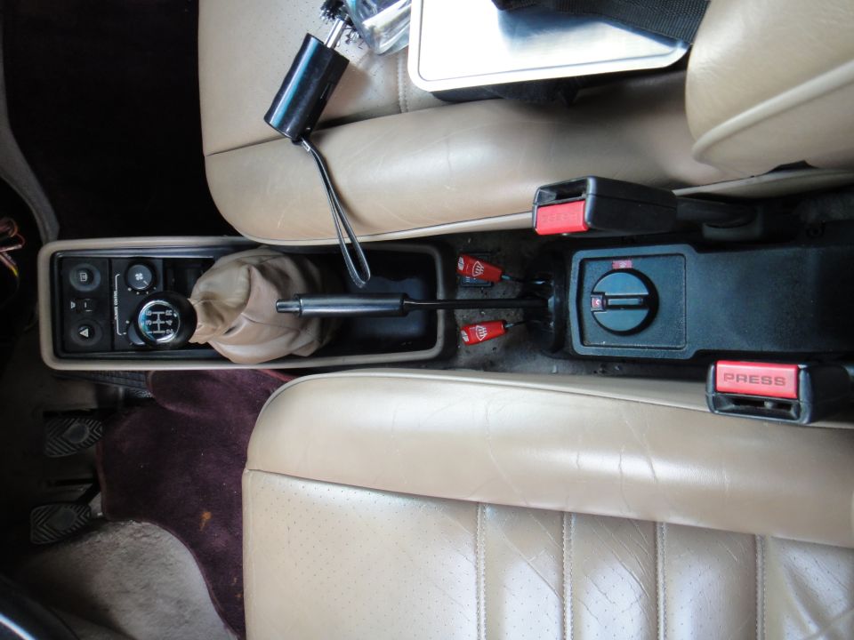 Interior view of 1986 Porsche 911 center console with manual shifter and seatbelts