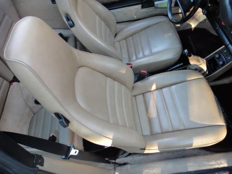 1986 Porsche 911 - The interior of a car shows tan leather seats and a portion of the dashboard.