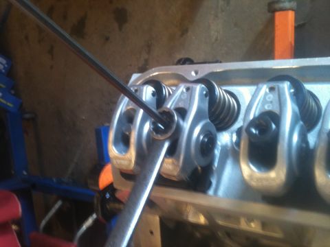 1993 Ford Bronco - Mechanic adjusts engine valve train components with a wrench.