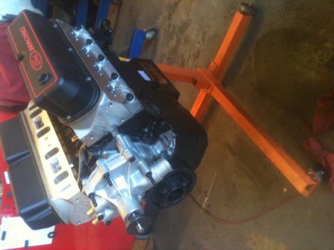 1993 Ford Bronco - Engine with black valve covers displaying "RACING" logo, mounted on an orange engine stand.