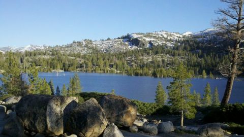 1971 Ford Bronco - Scenic view of a lake surrounded by pine trees and mountains, with snow on the peaks.
