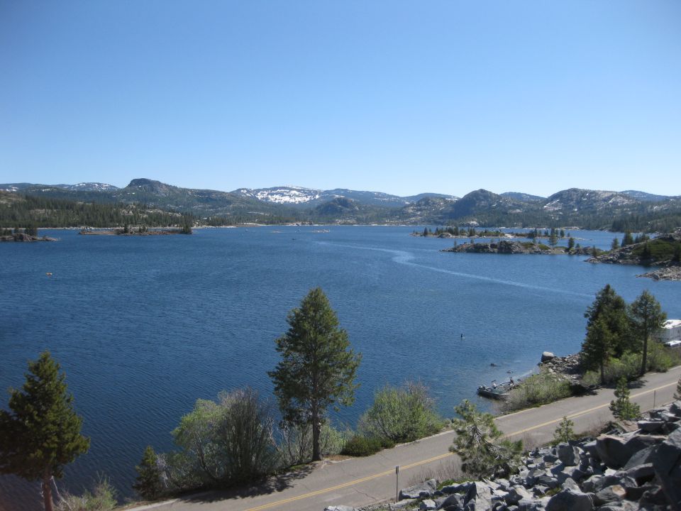 Scenic lake with mountains and trees under a clear blue sky
