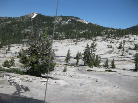 1971 Ford Bronco - A scenic view of a mountainous region with sparse vegetation and a bright blue sky overhead.