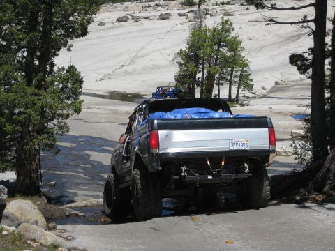 1971 Ford Bronco - Modified pickup truck navigates challenging rocky terrain with another vehicle following.
