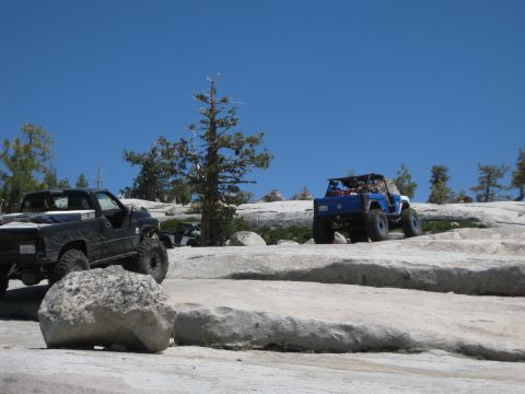 1971 Ford Bronco - Off-road vehicles traverse a challenging rocky landscape on a sunny day.