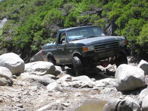 1971 Ford Bronco - Ford pickup truck tackles a challenging rocky trail, demonstrating its off-road capabilities.