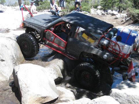 1971 Ford Bronco - This heavily modified off-road vehicle is shown navigating a challenging rocky trail.