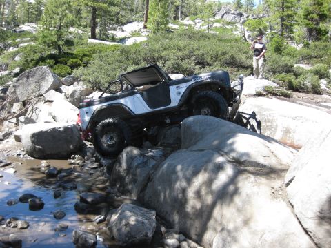 1971 Ford Bronco - This 1971 Ford Bronco is shown off-roading over large rocks and through a shallow stream.