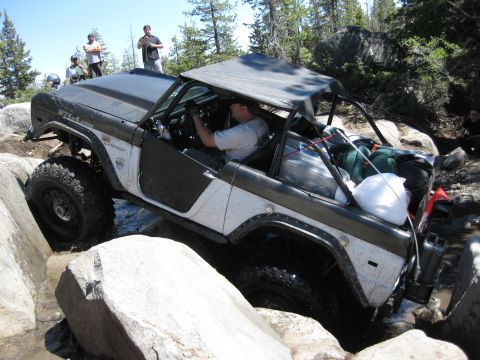 1971 Ford Bronco - This 1971 Ford Bronco is shown off-roading through a rocky stream, demonstrating its capability on challenging terrain.