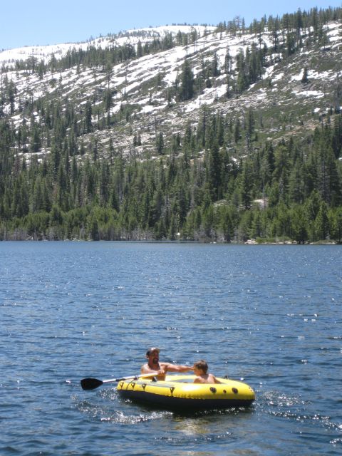 1971 Ford Bronco - Two people enjoy a day on the water in an inflatable boat, with a scenic mountain backdrop.