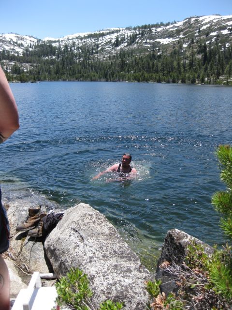 1971 Ford Bronco - A person enjoys a swim in a mountain lake on a sunny day.