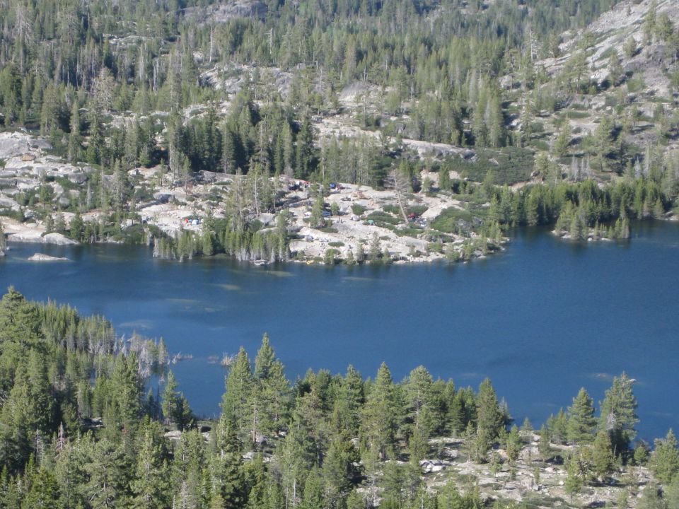 Mountain lake surrounded by pine trees and rocky terrain