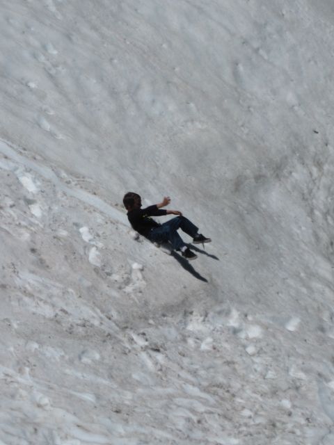1971 Ford Bronco - A person is captured mid-slide down a steep, snow-covered incline.