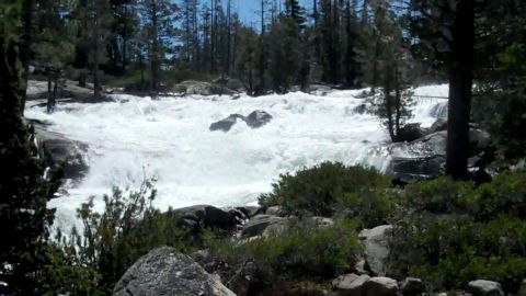 1971 Ford Bronco - A powerful river flows through a rocky, wooded landscape, creating white water rapids.