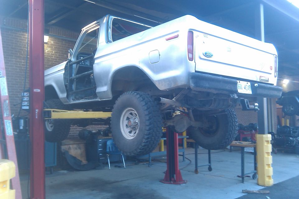 Silver 1978 Ford Bronco on a lift, rear view