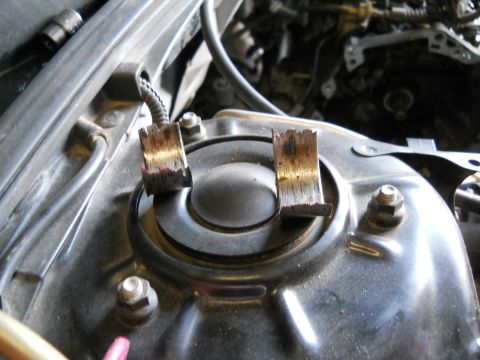 2006 Ford E350 - Close-up of two damaged metal components on a vehicle's suspension system.