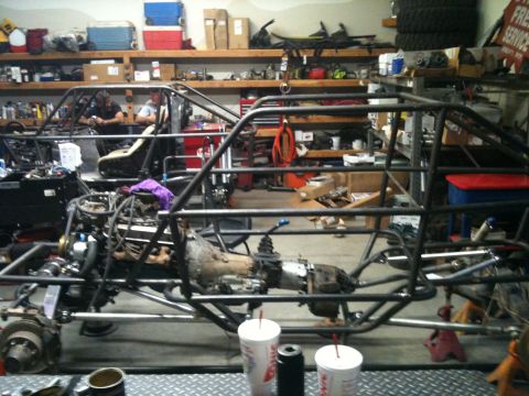 1966 Ford Bronco - Two custom buggy frames are visible in a garage, one with its engine and transmission installed.