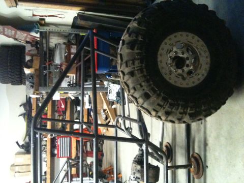 1966 Ford Bronco - This unfinished buggy frame is in a garage, with a large tire prominently displayed.
