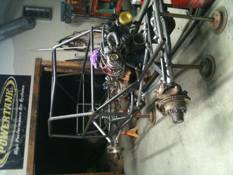 1966 Ford Bronco - A custom-built buggy chassis with an engine and suspension parts is shown in a workshop setting.