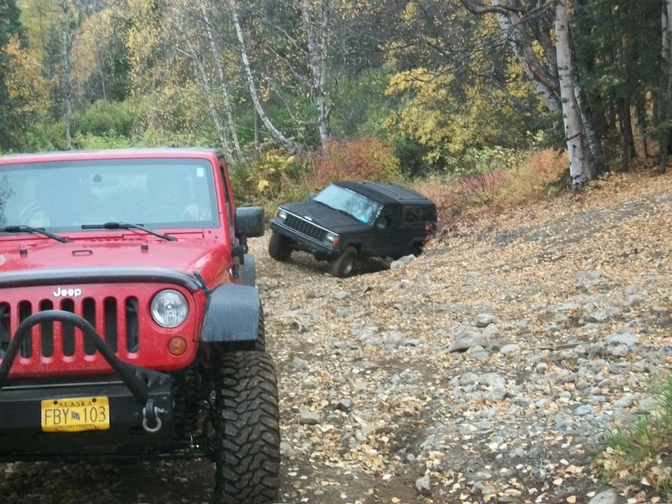 Red Jeep in foreground, black Jeep on a rocky trail in background