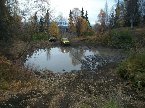 1979 Ford Bronco - Off-road vehicles tackle a challenging muddy terrain during autumn.