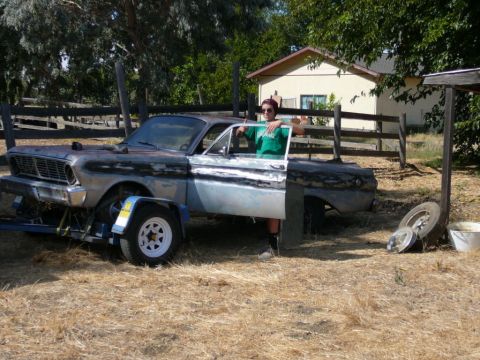 1988 Ford Bronco - A person stands by a vintage Ford Falcon Ranchero, which appears to be undergoing restoration or transport.