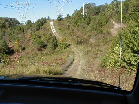 1995 Ford Bronco - Driving up a dirt road with power lines overhead.
