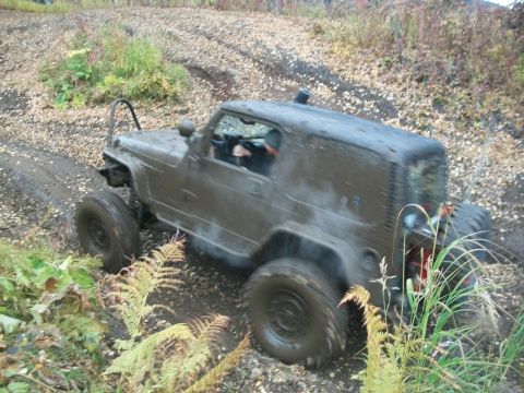 1979 Ford Bronco - An off-road vehicle navigates a muddy, leaf-strewn path during an outdoor excursion.