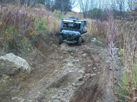 1979 Ford Bronco - An off-road vehicle navigates a challenging, rocky terrain with another vehicle visible behind it.