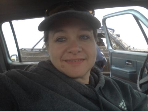 1990 Chevrolet Suburban - Interior view of a woman in a pickup truck, with a glimpse of the exterior and another vehicle behind.