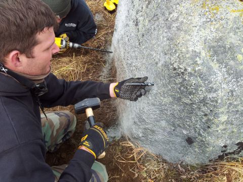 1990 Chevrolet Suburban - Workers are shown drilling holes into a large boulder, possibly for geological study or construction purposes.