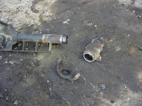 1992 Ford Bronco - Damaged axle parts lie on the ground next to a metal support structure. The Supermotors.net logo is visible in the lower right corner.
