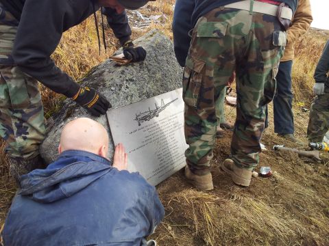 1990 Chevrolet Suburban - A group of people examine a memorial plaque detailing an aircraft incident.