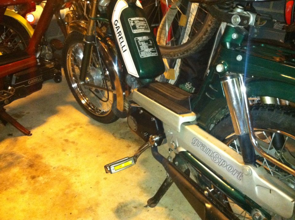 Side view of a green Garelli Gran Sport moped parked next to another moped