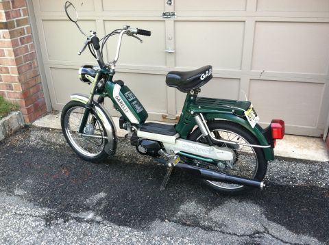 1981 Garelli Rally Sport - A green and white Garelli moped is parked on an asphalt driveway in front of a garage.