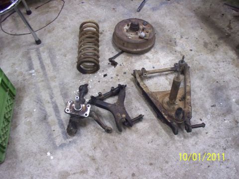 1990 Ford Bronco - Various rusty car suspension components are laid out on a concrete surface.