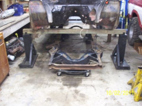1990 Ford Bronco - The vehicle's frame is elevated on stands as work is done on the suspension components.