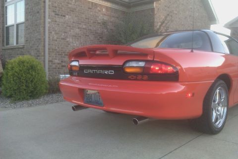 1999 Chevrolet Camaro - Rear view of a red 1999 Chevrolet Camaro, its distinctive spoiler and dual exhaust pipes.