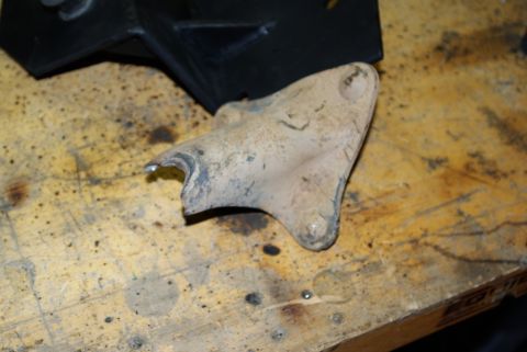 1995 Ford Bronco - Close-up of a metal bracket on a workbench, likely a vehicle part.