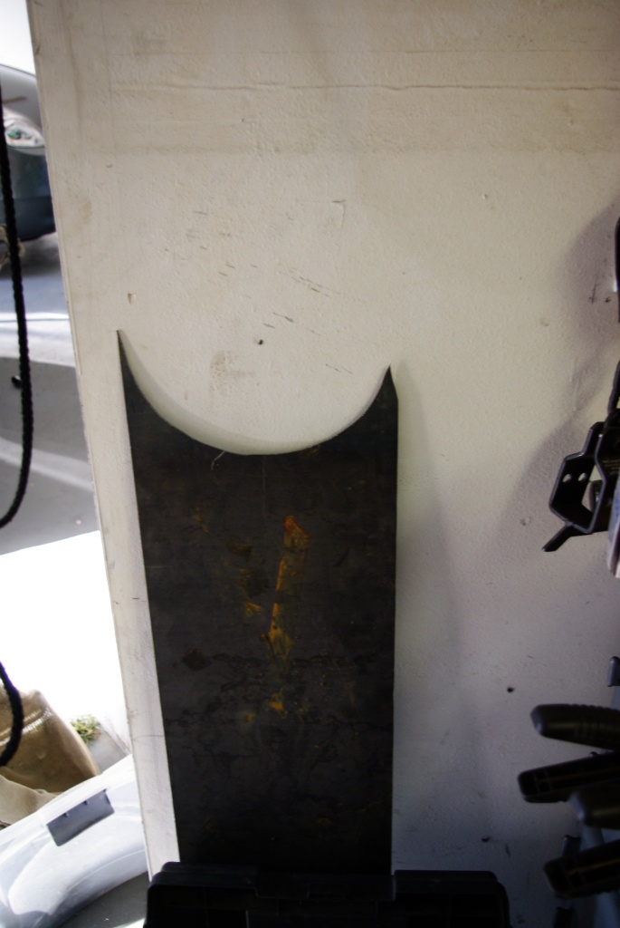 dark curved metal panel leaning against a wall