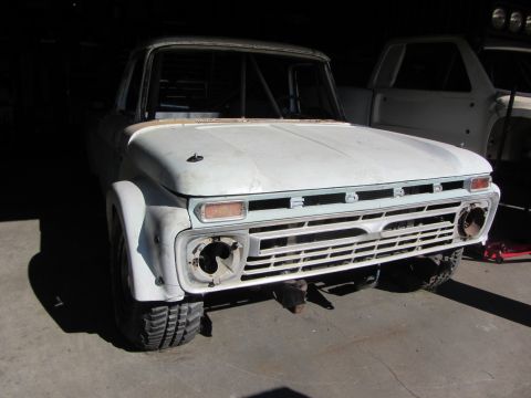 1987 Suzuki Samurai - This white pickup truck, possibly a custom build, is shown from the front with a roll cage visible inside the cab.