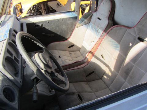 1987 Suzuki Samurai - The interior of a vehicle shows racing seats and a roll cage, with another vehicle visible in the background.