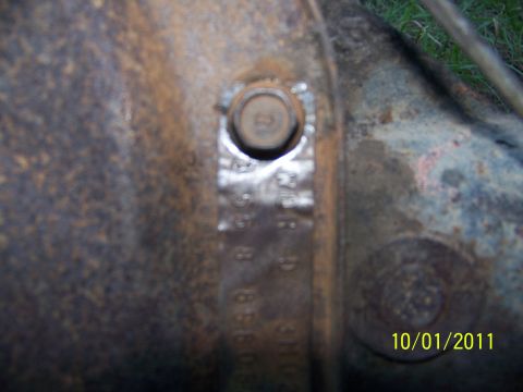 1986 Ford Bronco - Close-up of a rusty differential housing with stamped identification numbers.