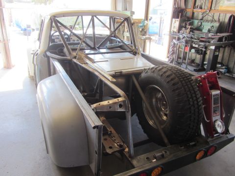 1987 Suzuki Samurai - This custom off-road vehicle features a prominent roll cage and a spare tire mounted in the rear bed.