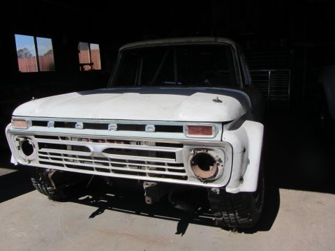1987 Suzuki Samurai - This vintage Ford truck, identifiable by its grille, appears to be undergoing restoration or modification.