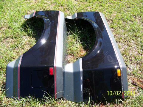 1986 Ford Bronco - Two vehicle fenders with decorative stripes are laid out on grass.